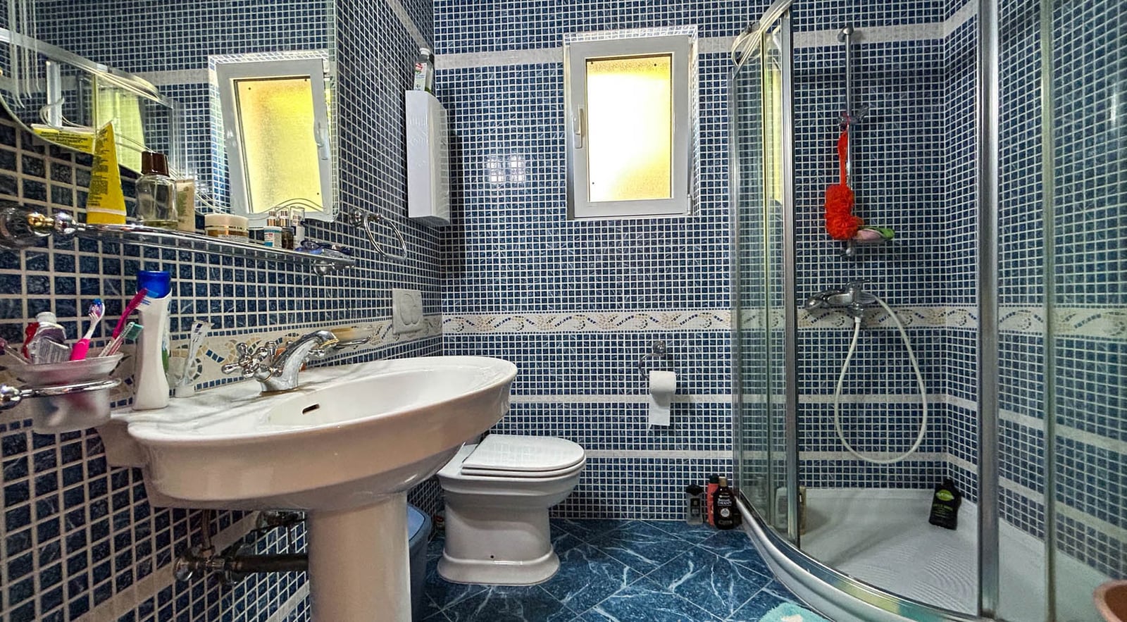 Badezimmer mit blauer Mosaikfliese und Duschkabine in einer Villa in Dobrota, Montenegro.
