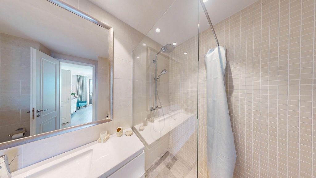 Modern banyo, duşakabinli daire, Luštica, Karadağ: açık renkli fayans, ayna ve sıhhi tesisat.