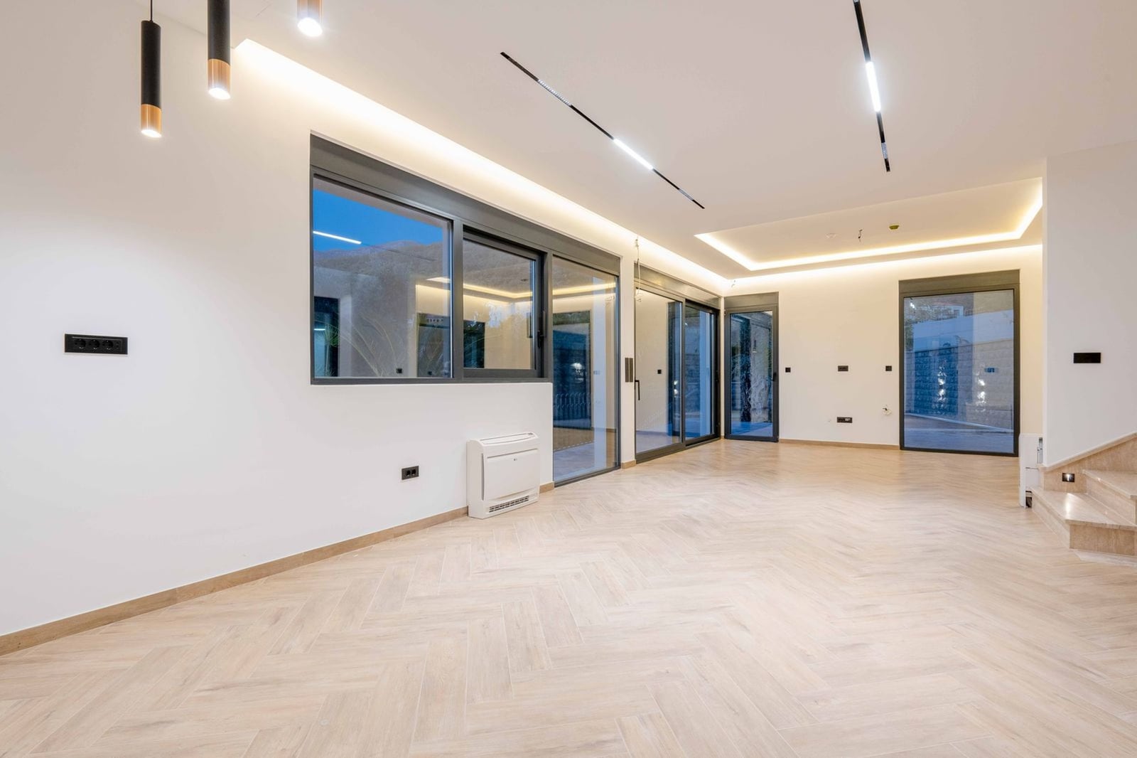 Salon spacieux avec fenêtres panoramiques et parquet dans une nouvelle villa, Kamenovo, Monténégro. Design d'intérieur moderne.