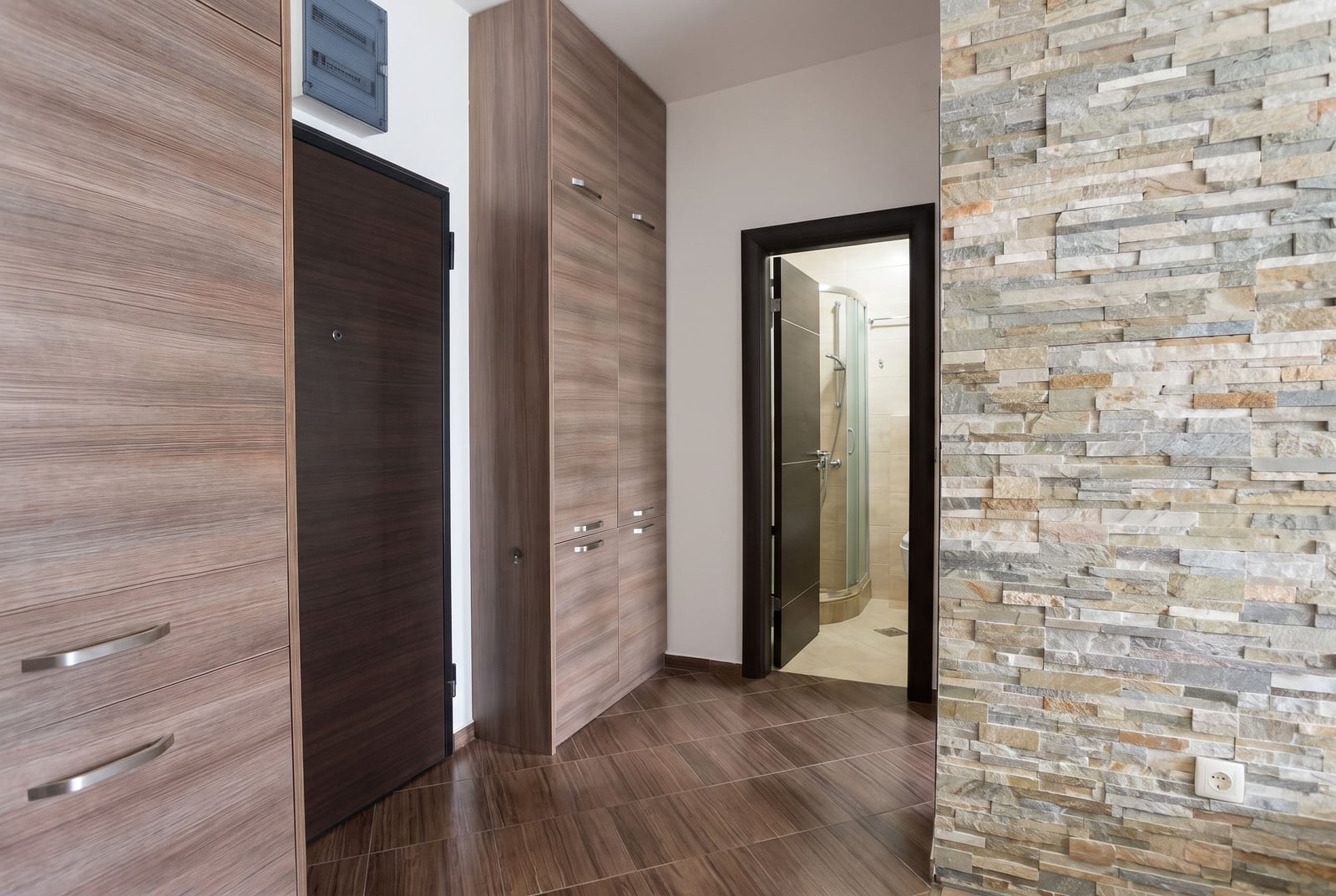 Moderner Flur mit eingebauten Holzschränken und Steinverkleidung in einer Wohnung in Budva, Montenegro