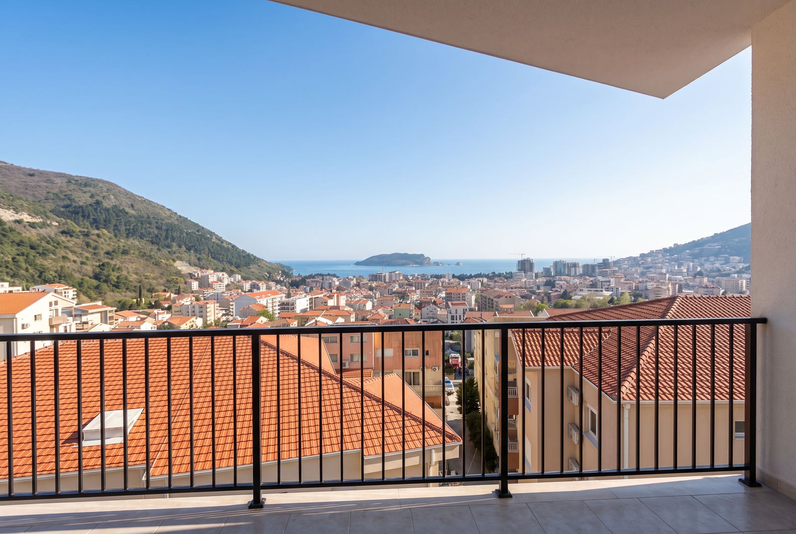 Panoramic view of the sea, city, and mountains from the spacious balcony of an apartment in Budva, Montenegro