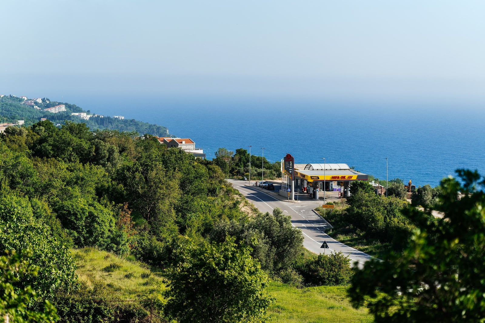 Panoramski pogled na Jadransko more, put i zelena brda pored vile u Blizikuči, Crna Gora