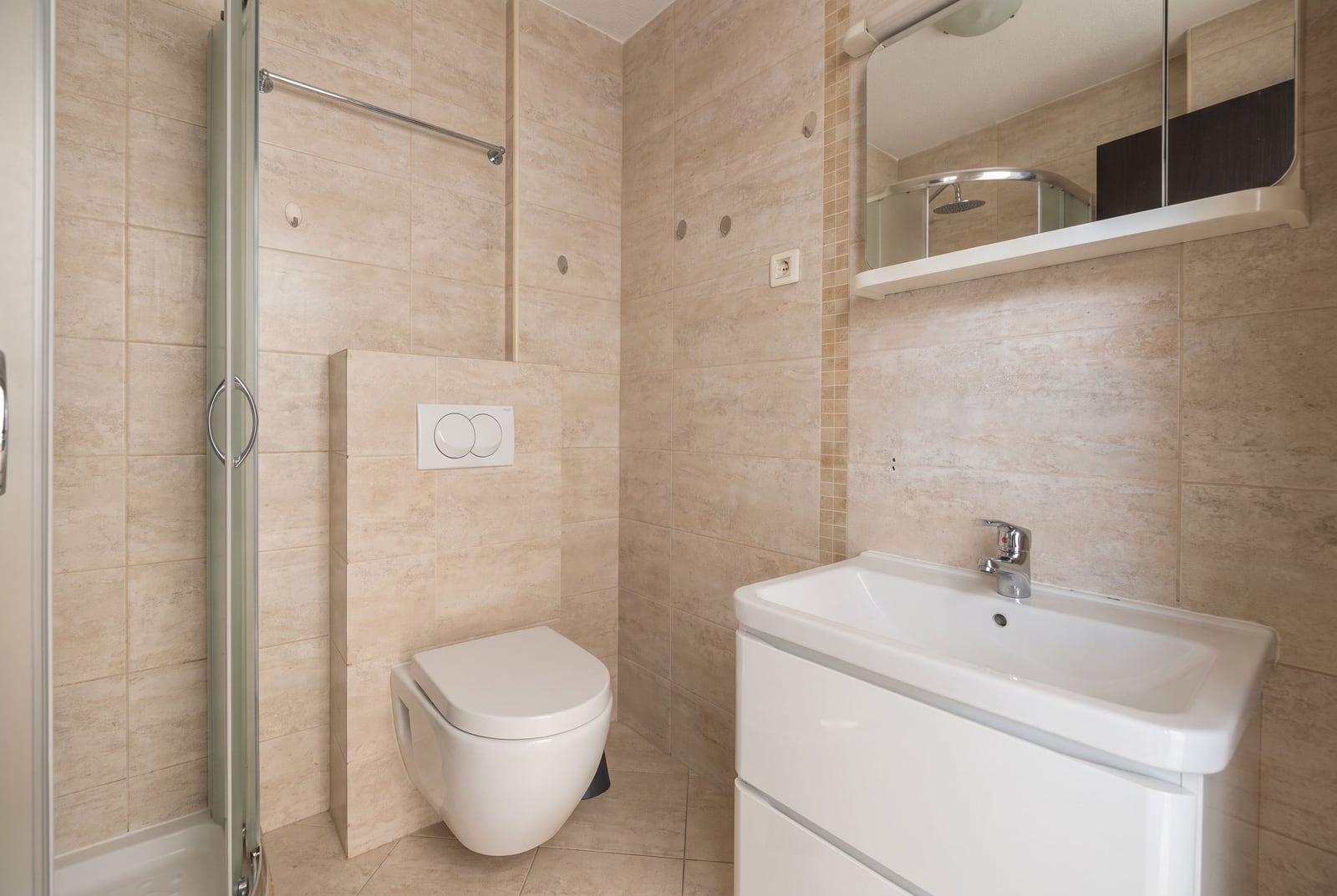 Modernes Badezimmer mit Dusche und weißer Sanitärkeramik in einer Wohnung in Budva, Montenegro
