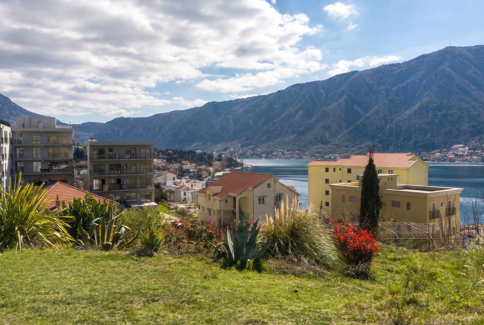 Panoramski pogled na Boku Kotorsku, planine i stambene zgrade u Dobroti, Crna Gora