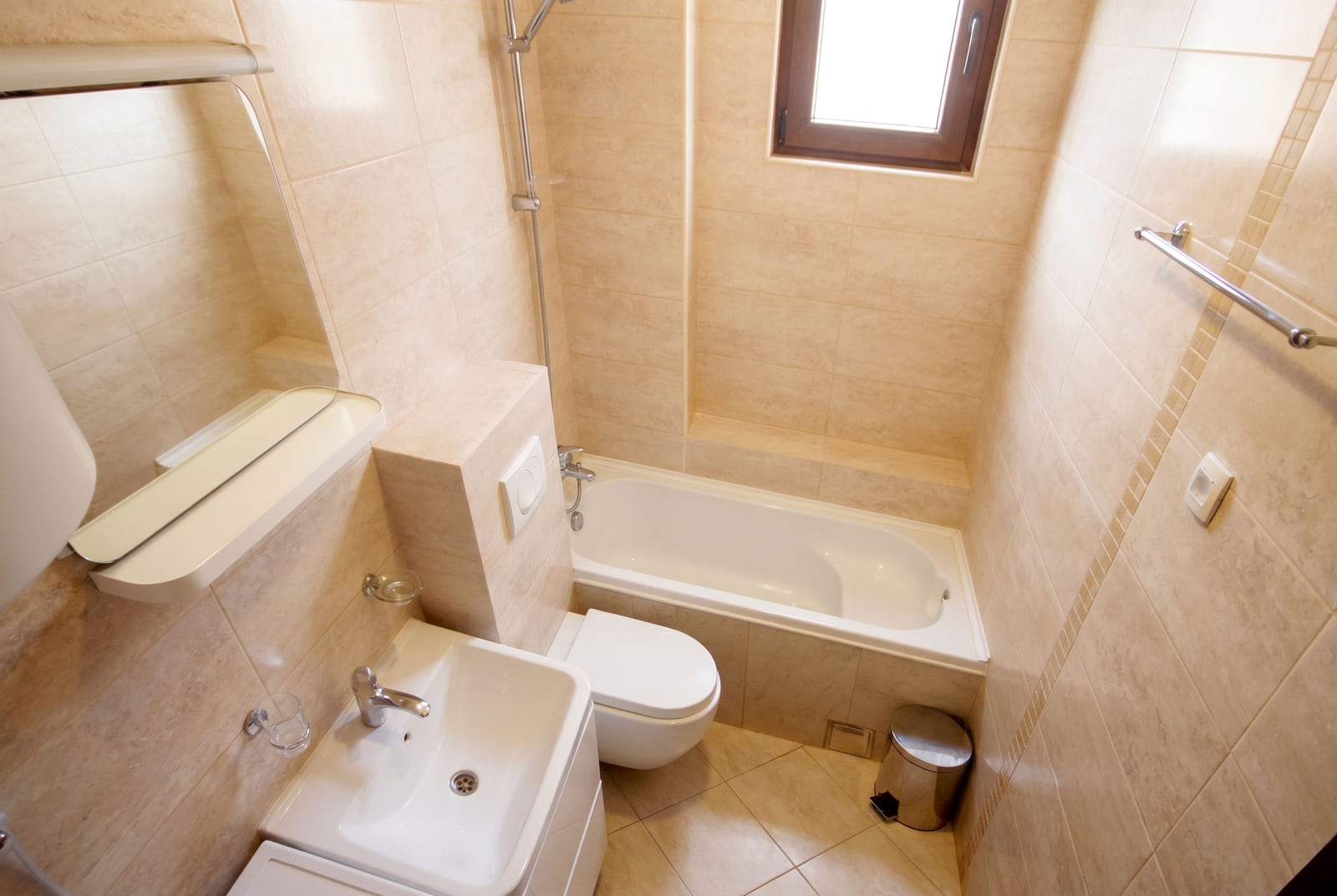 Modern bathroom with white sanitary ware and beige tiles in an apartment in Budva, Montenegro.