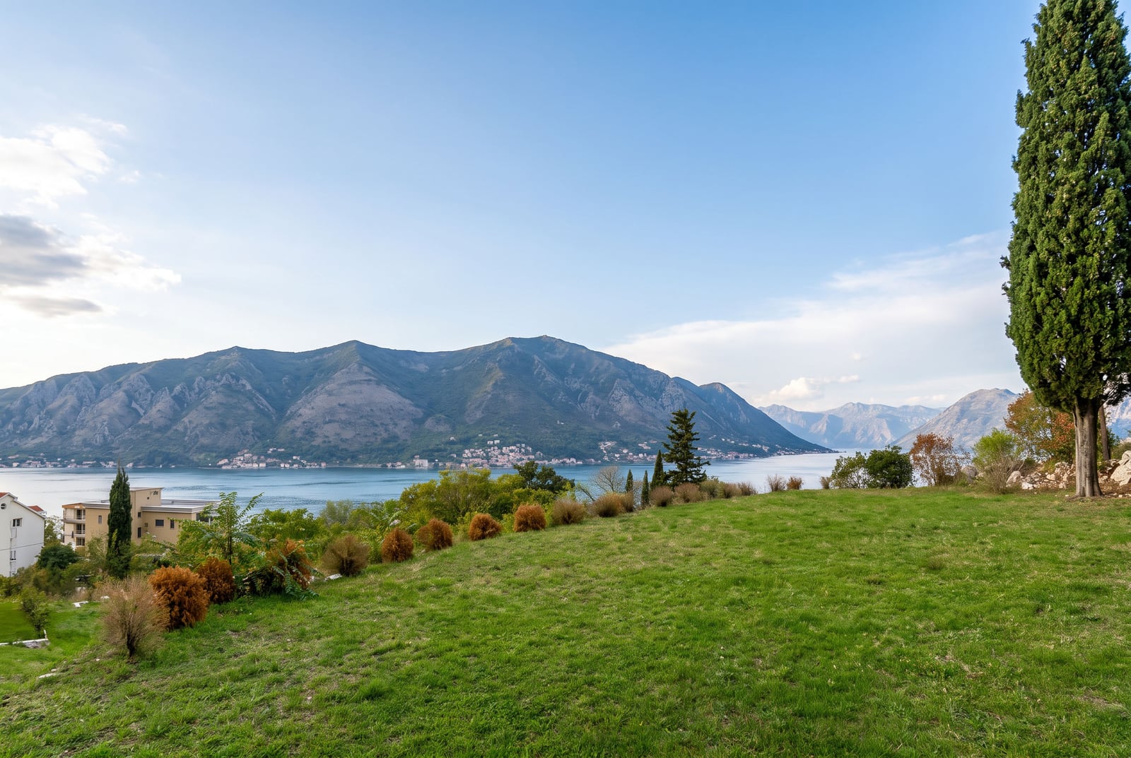 Panoramski pogled na Boku Kotorsku, planine i zelenu parcelu u Dobroti, Crna Gora