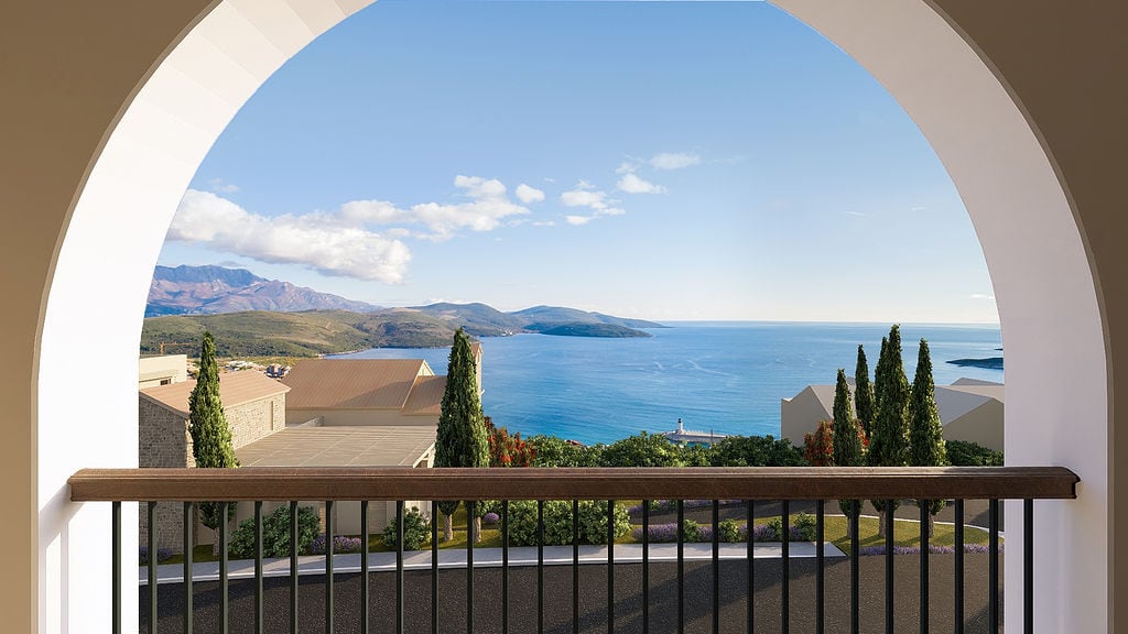 Blick vom Bogenbalkon auf das Meer, die Berge und die Villen an der Küste im Wohnkomplex Luštica, Montenegro.