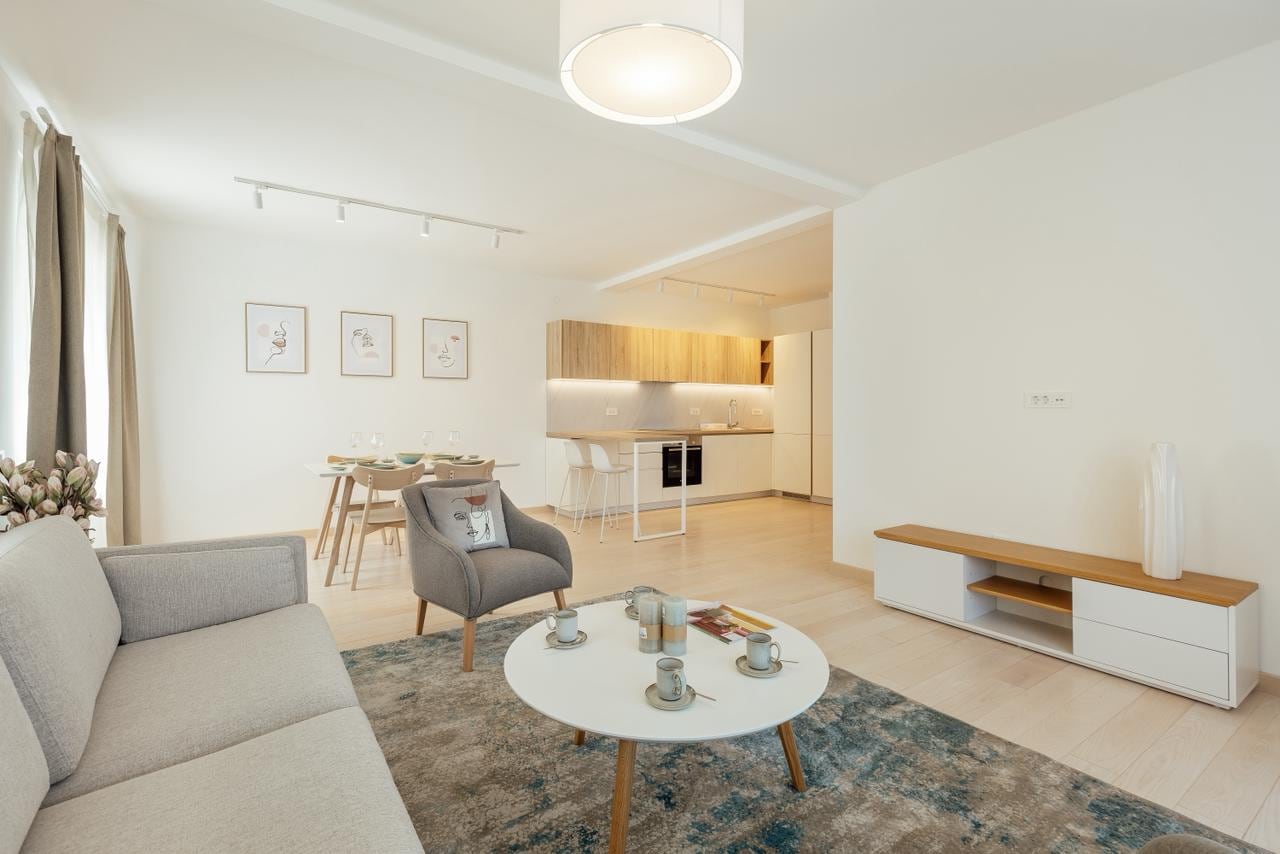 Modernes Wohnzimmer mit Küche in einem Apartment, Igalo, Montenegro: helles Interieur, Polstermöbel und Essbereich.