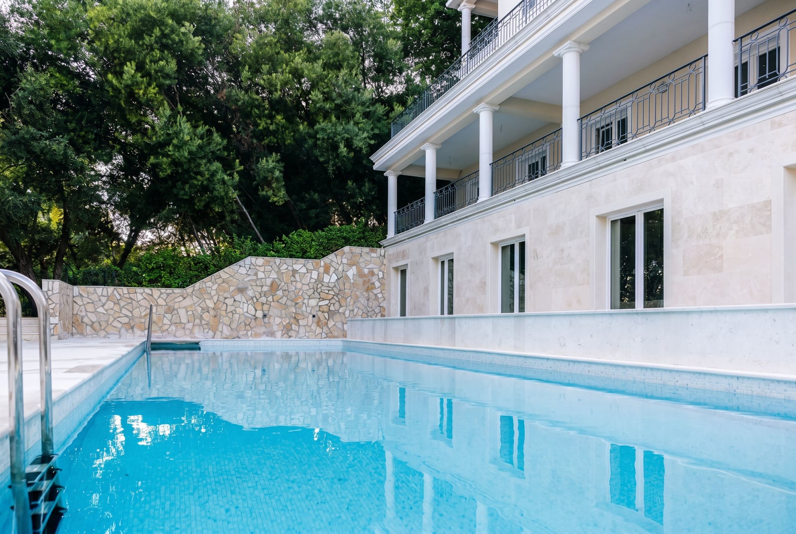 Villa de luxe avec piscine et finitions en pierre à Kumbor, Monténégro : vue sur la façade avec colonnes et terrasse.