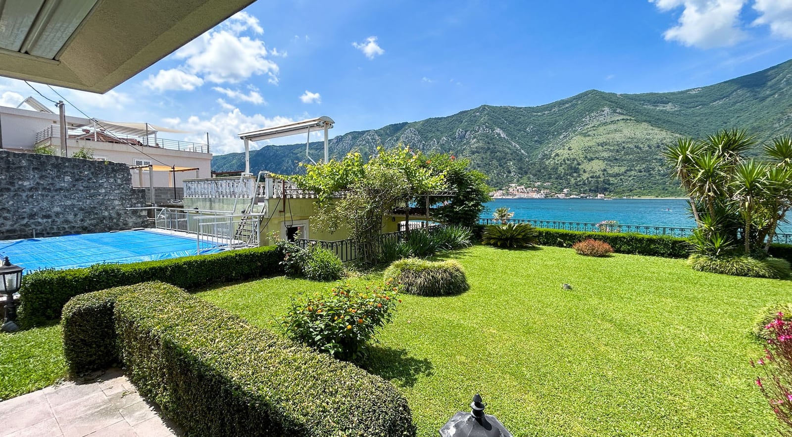 Grüner Garten mit Pool und Panoramablick auf die Bucht von Kotor, Villa in Dobrota, Montenegro.