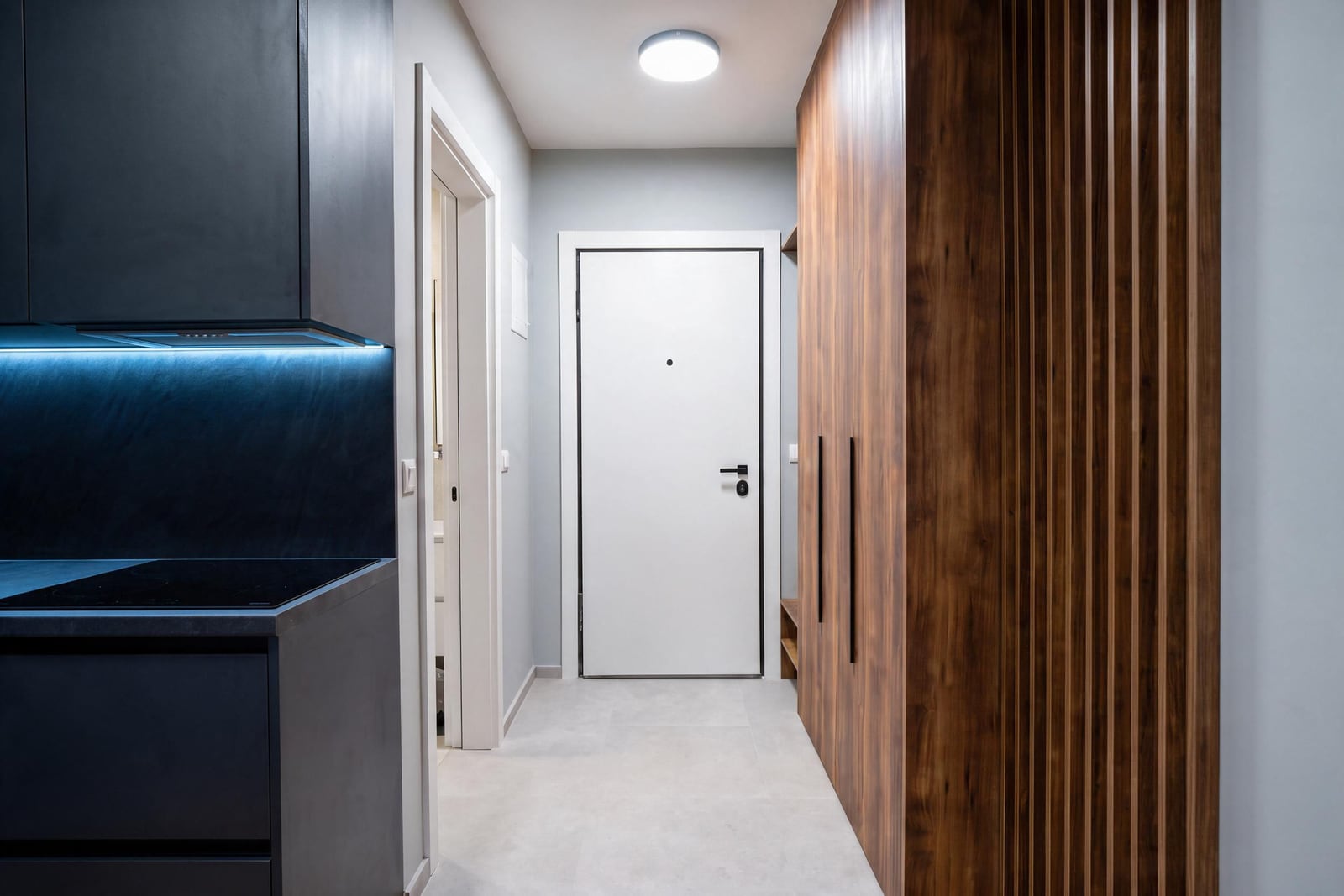 Modern interior of a hallway and kitchen with wooden panels and furniture in an apartment in Budva, Montenegro