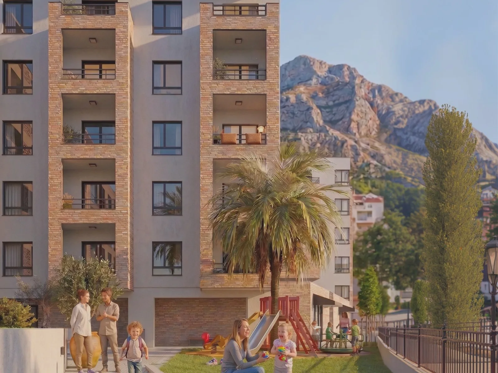 Balconylı, palmiye ağaçlı ve oyun alanlı çok katlı konut binasının dış görünümü, arka planda dağlar.
