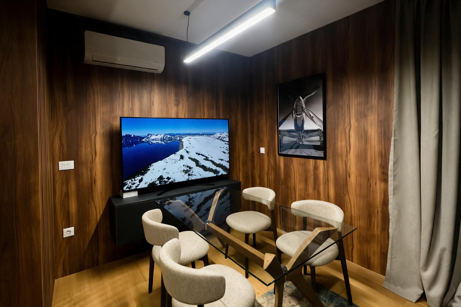 Modern living room with wooden wall paneling, glass table, and TV in a luxury apartment in Budva, Montenegro.