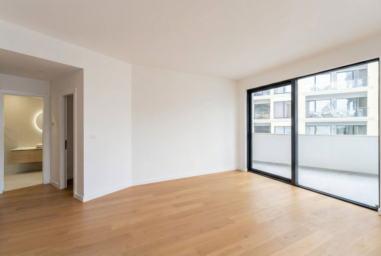 Svetao dnevni boravak sa panoramskim prozorom i izlazom na balkon u novom stanu, Bečići, Crna Gora.
