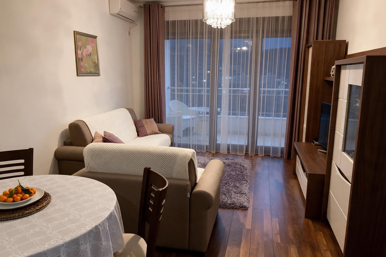 Cozy living room with a sofa, furniture set, and access to the balcony in an apartment in Budva, Montenegro.