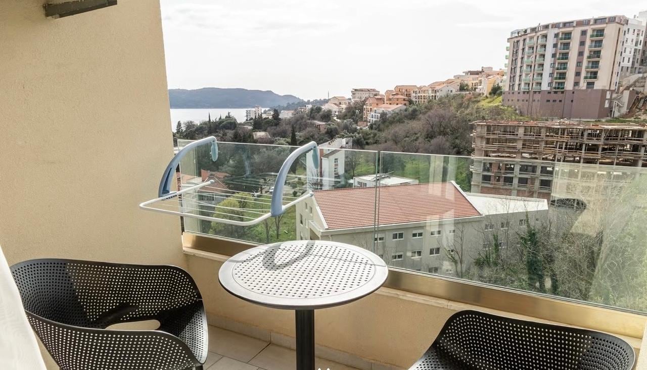 Furnished balcony with a panoramic view of the sea and mountains in a residential complex in Bečići, Montenegro.