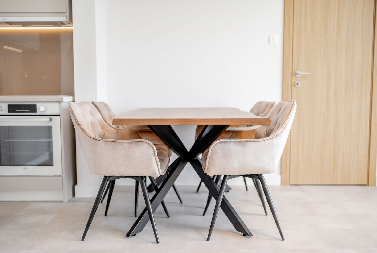 Dining area with a wooden table and upholstered chairs in a modern apartment in Sveti Stefan, Montenegro