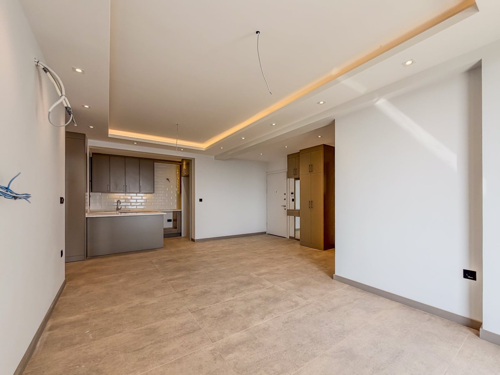 Spacious living room with kitchen and tiled floor in a new apartment in Budva, Montenegro
