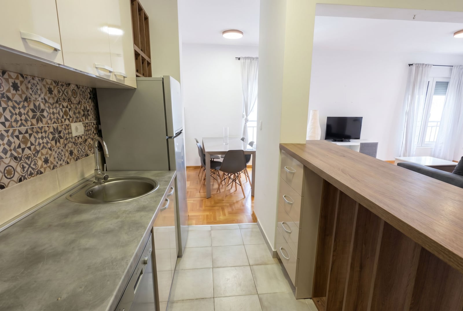 Bar tezgahlı ve yemek alanlı modern mutfak, Budva, Karadağ. Fayanslı ve mobilyalı iç mekan.
