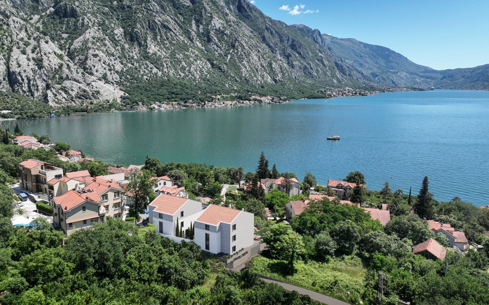 Modern houses with tiled roofs against the backdrop of mountains and the Bay of Kotor in Orahovac, Montenegro