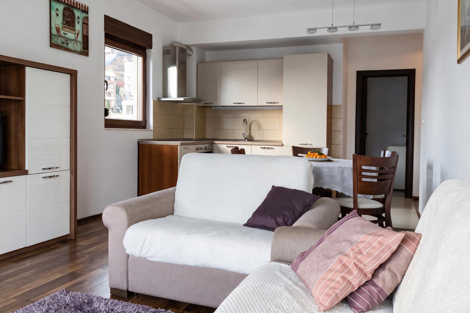 Bright living room with upholstered furniture and kitchen in an apartment in Budva, Montenegro