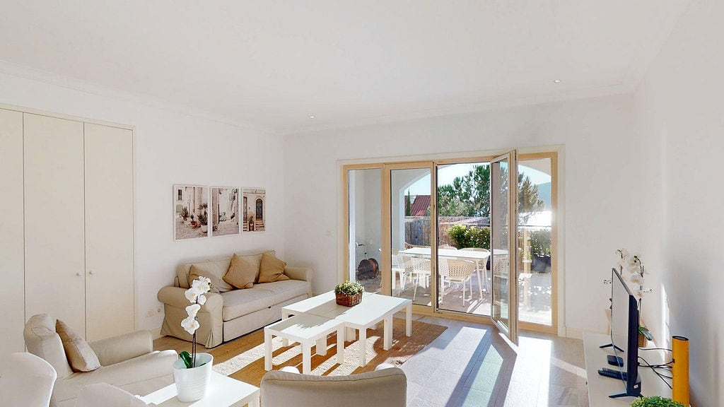Helles Wohnzimmer mit Zugang zur Terrasse in einer Wohnung, Luštica, Montenegro: weiße Möbel, modernes Interieur und Blick auf den Garten.