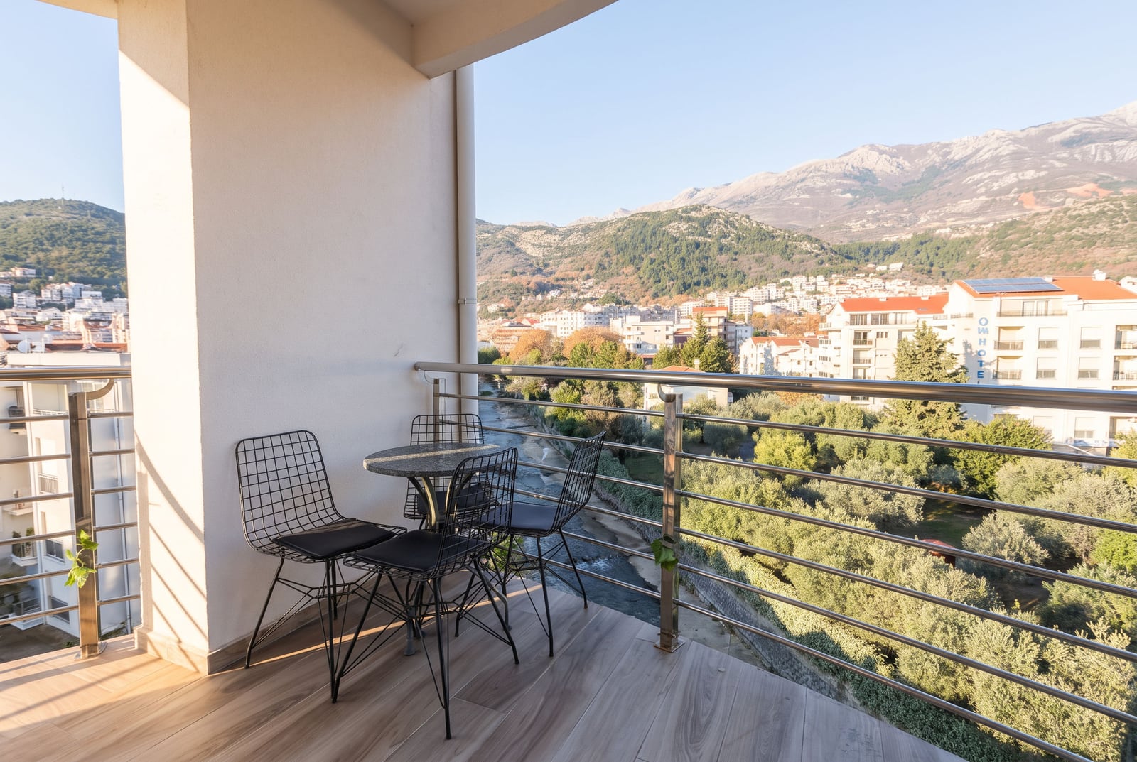 Balkon sa metalnim nameštajem, panoramskim pogledom na planine i grad u Budvi, Crna Gora