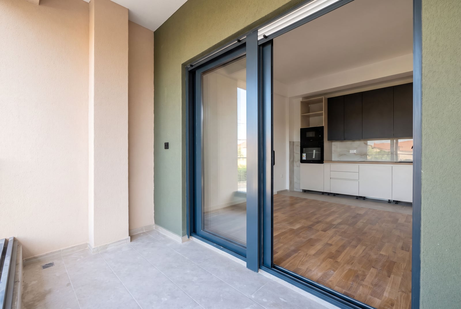 View from the balcony of a modern kitchen in an apartment, Bar, Montenegro: panoramic sliding doors and stylish interior.
