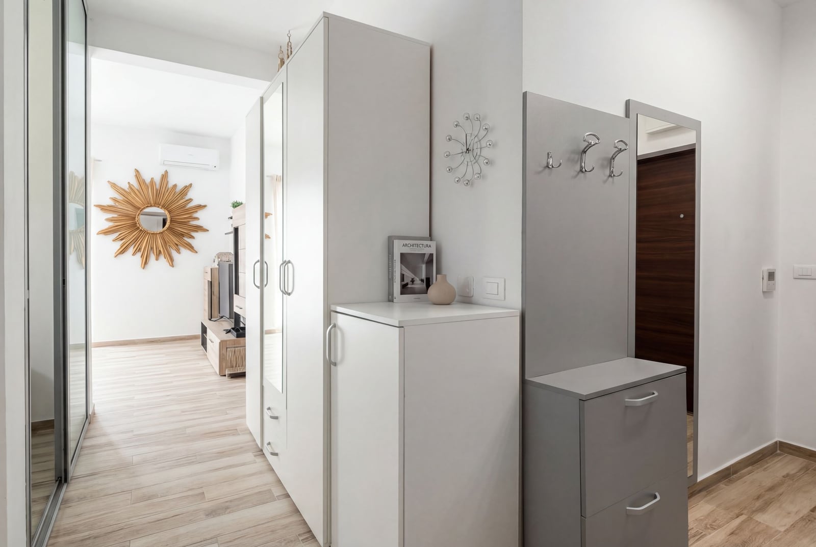 Helle Diele mit weißem Schrank und Spiegel in einer modernen Wohnung in Bečići, Montenegro.