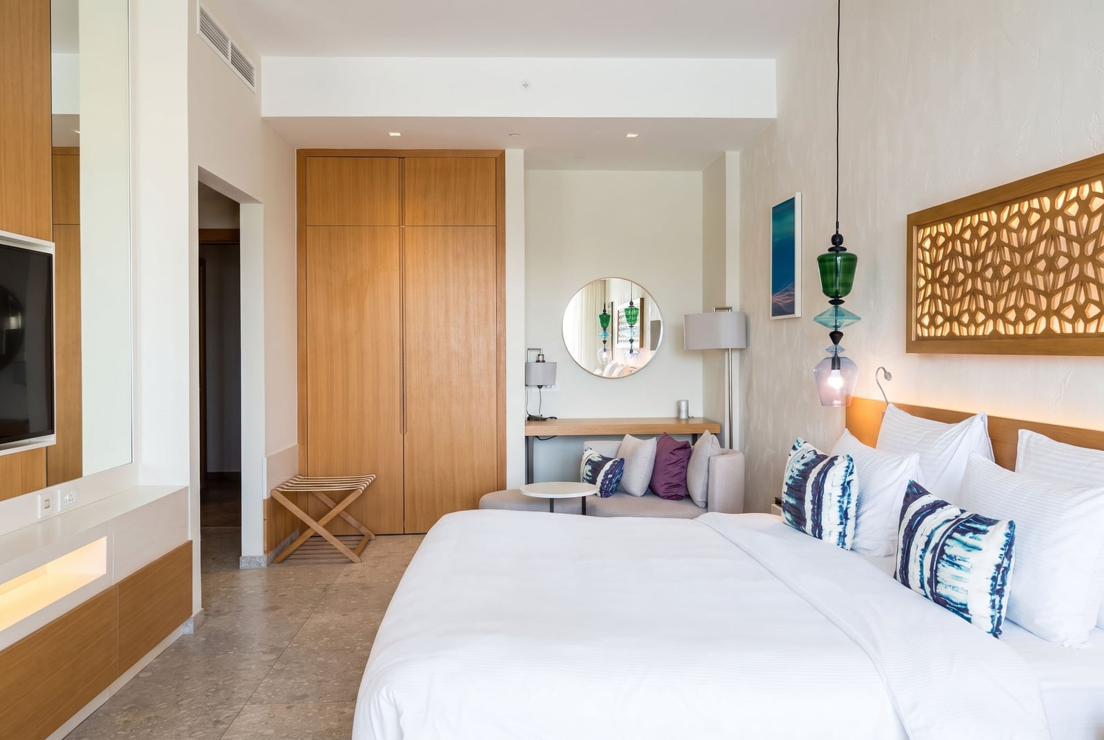 Modernes Schlafzimmer im Hotel Luštica Bay, Montenegro: Doppelbett, Holzschrank und stilvolles Dekor.