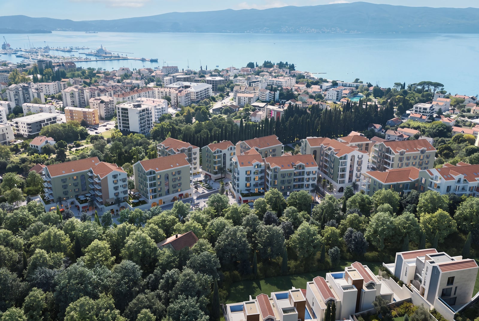 Aerial view of a residential complex with tiled roofs and greenery in Tivat, Montenegro.