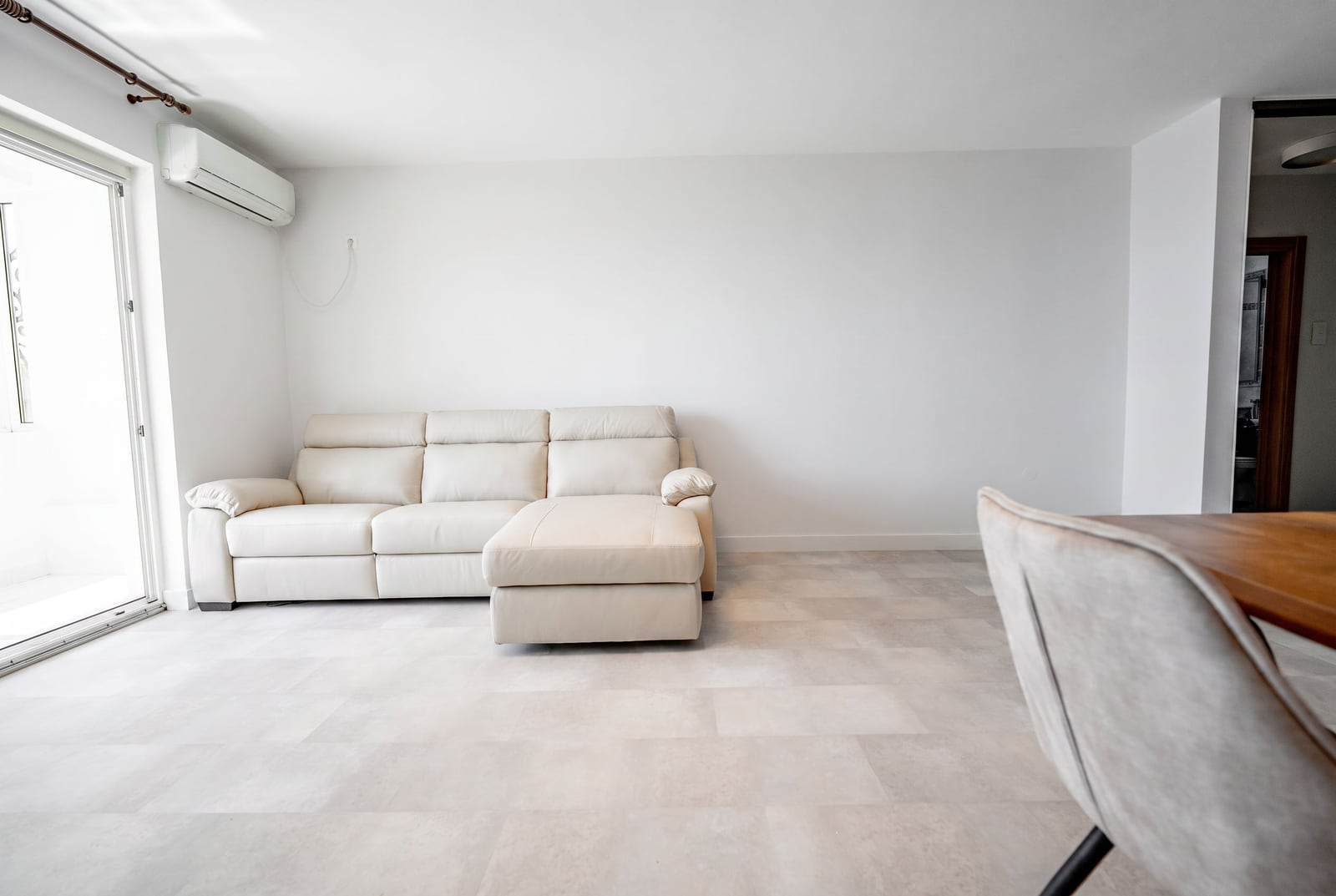 Bright living room with a white leather sofa and tiled floor in an apartment at the Sveti Stefan resort, Montenegro.