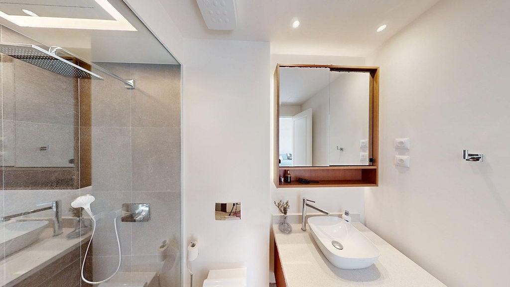 Modernes Badezimmer in einer Wohnung, Luštica, Montenegro: Duschkabine, Aufsatzwaschbecken und Spiegelschrank.
