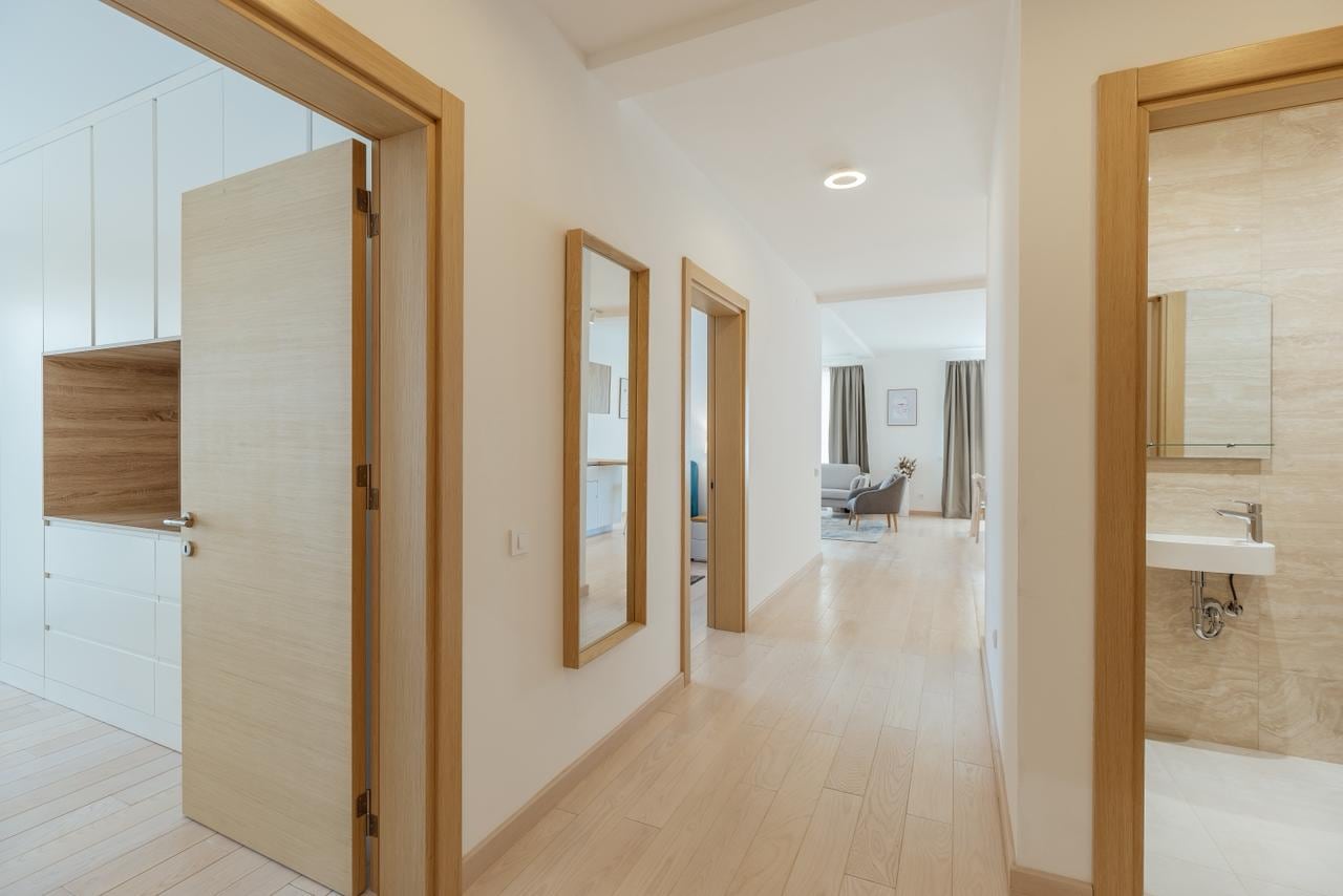 Heller Flur in einer modernen Wohnung in Igalo, Montenegro: Einbauschrank, Spiegel und Zugang zum Badezimmer.