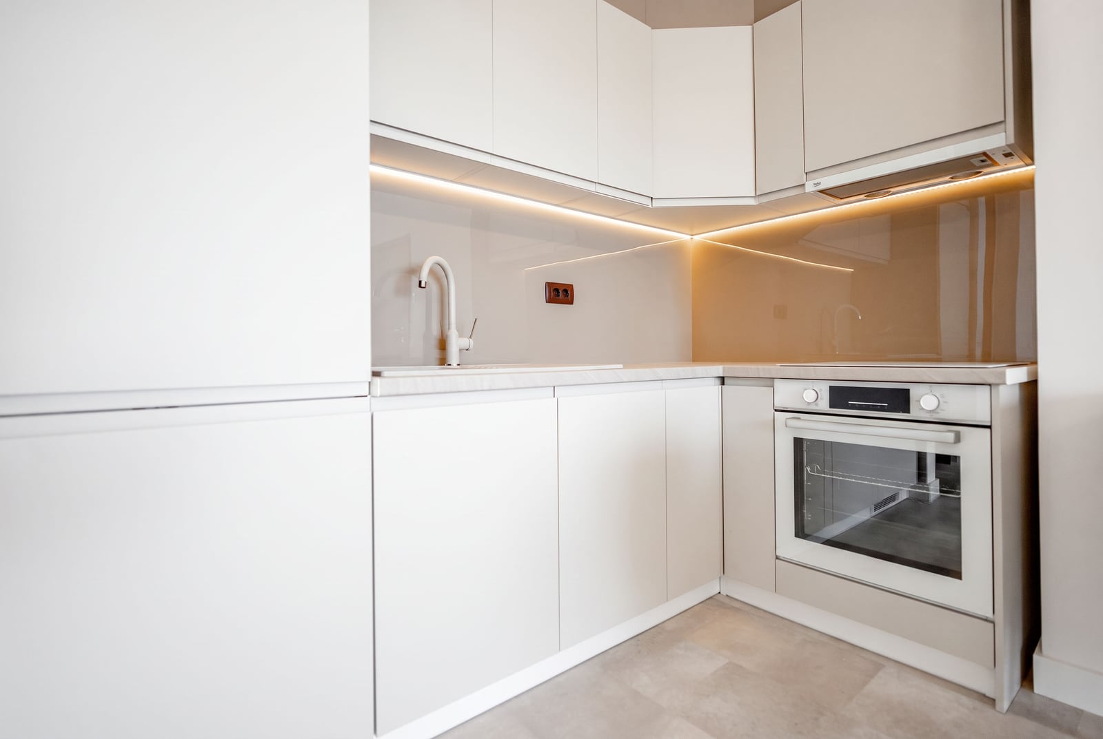 Modern white kitchen with built-in appliances in an apartment, Sveti Stefan, Montenegro: stylish design and lighting.