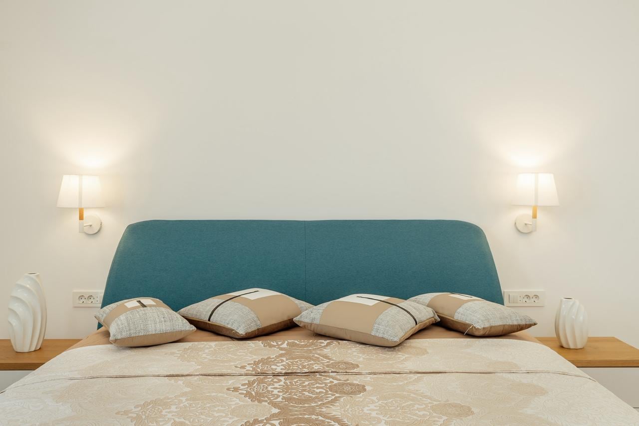 Modernes Schlafzimmer mit Doppelbett und blauem Kopfteil in einer Wohnung, Igalo, Montenegro.