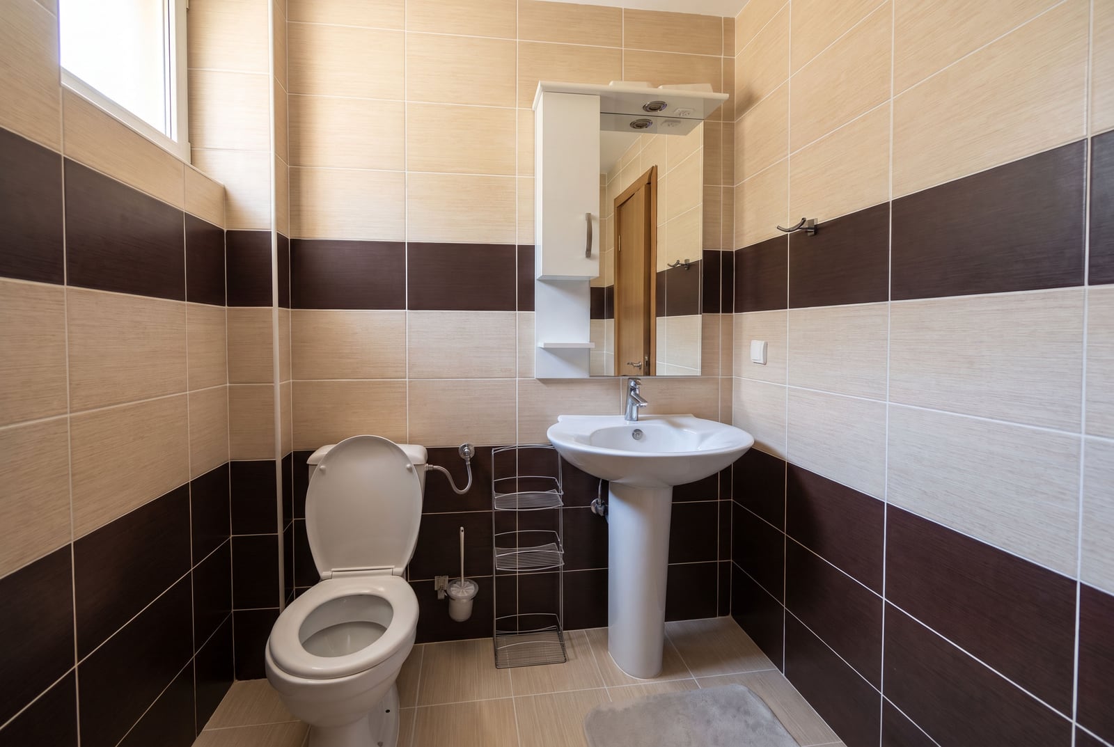 Moderna kupatilo u stanu u Tivtu, Crna Gora: bela sanitarija, umivaonik na postolju, ogledalo sa ormarićem i od...