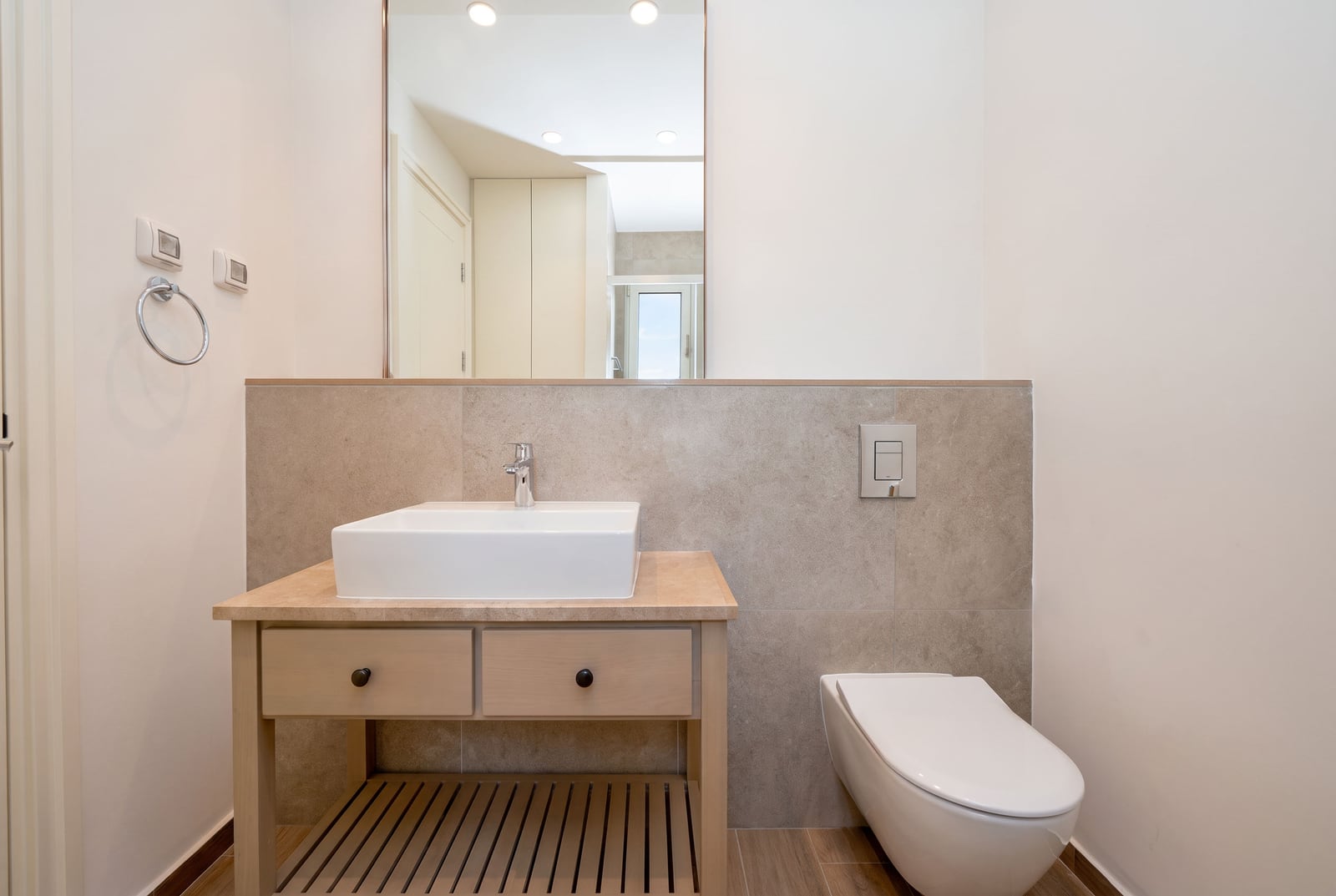 Modernes Badezimmer mit weißem Waschbecken, Unterschrank und Vorwandelement in einer Wohnung in Luštica, Montenegro