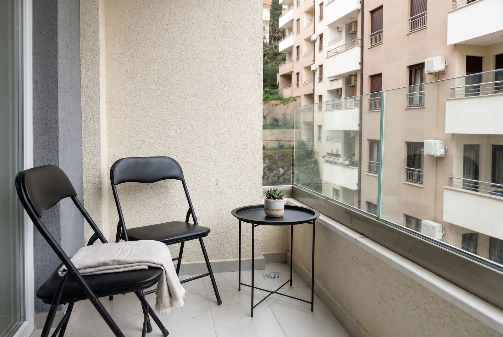 Balkon mit schwarzen Möbeln und Glasgeländer in einer Wohnung, Bečići, Montenegro.