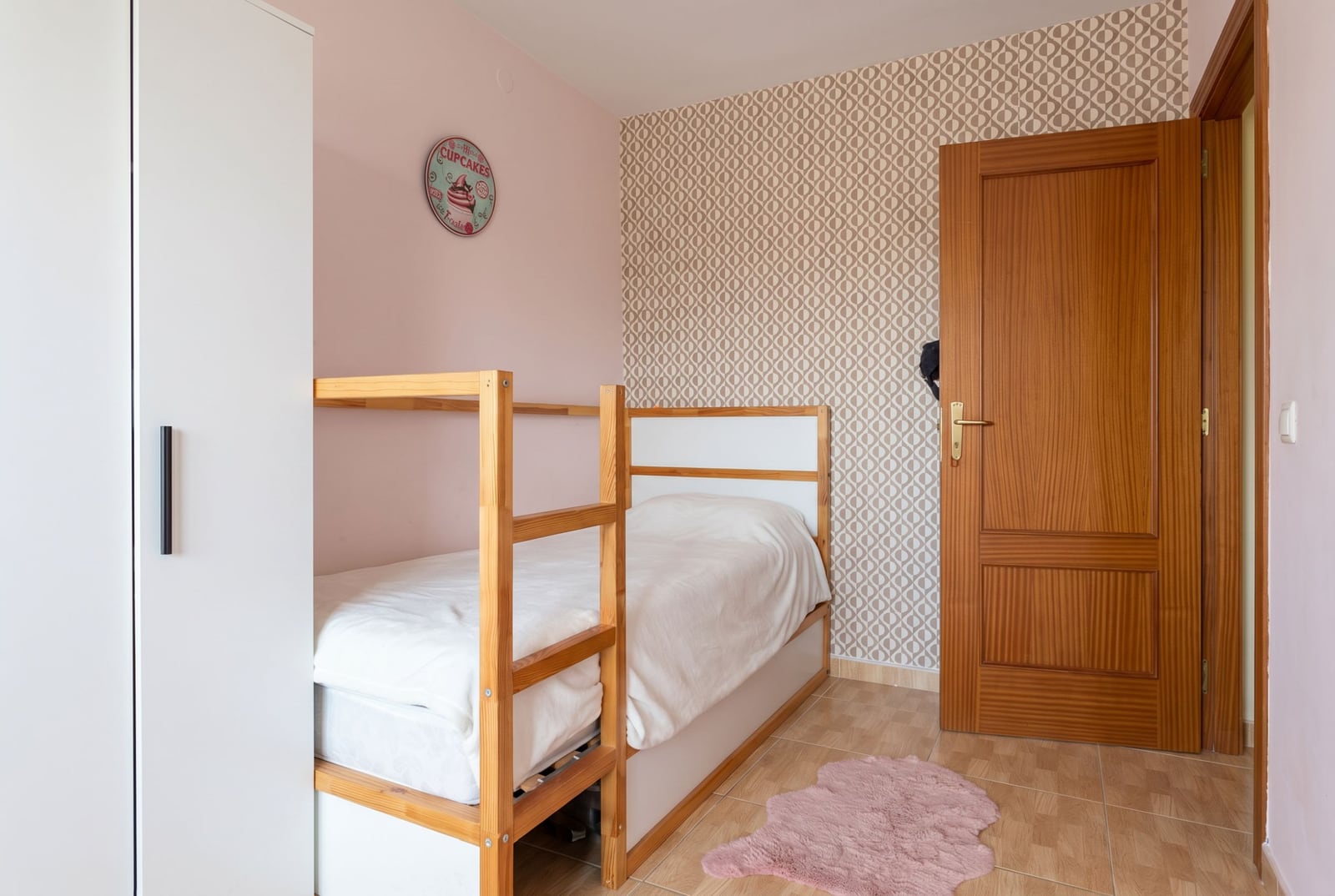 Children's bedroom with a bunk bed in an apartment in Budva, Montenegro: bright interior, wardrobe, and wooden door.