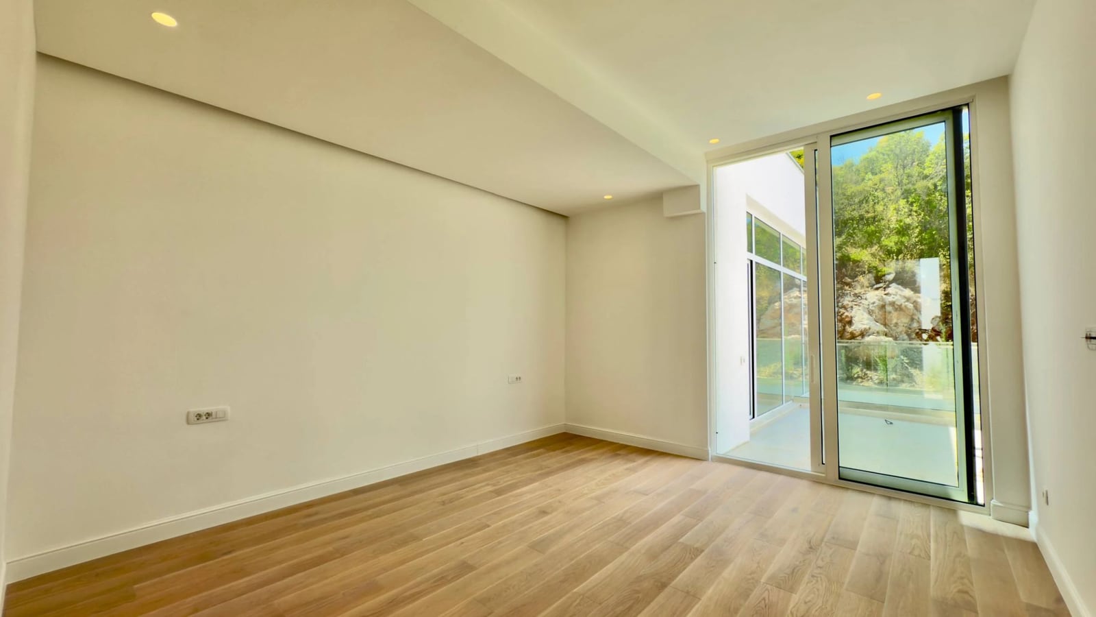 Helles Wohnzimmer mit Panoramafenstern und Blick ins Grüne in einer modernen Villa, Krašići, Montenegro.