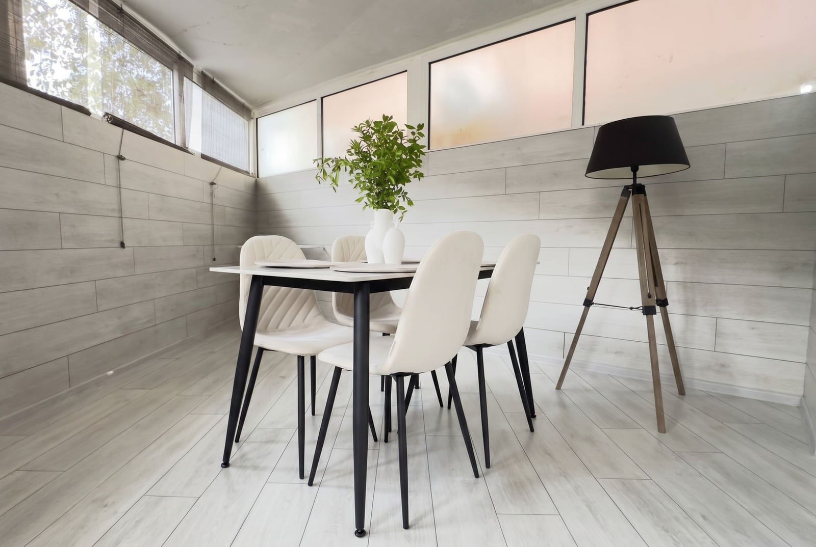 Modern dining area in an apartment in Budva, Montenegro: bright interior, stylish chairs, and a tripod floor lamp.