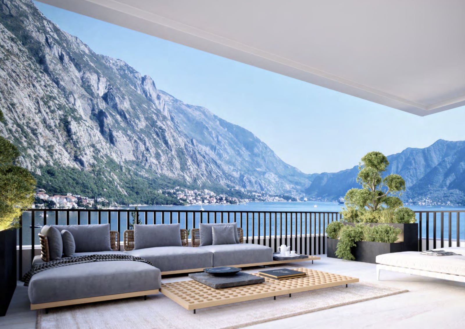 Spacious penthouse terrace in Orahovac, Montenegro, with a soft gray sofa, coffee table, and panoramic views of the Bay of Kotor.