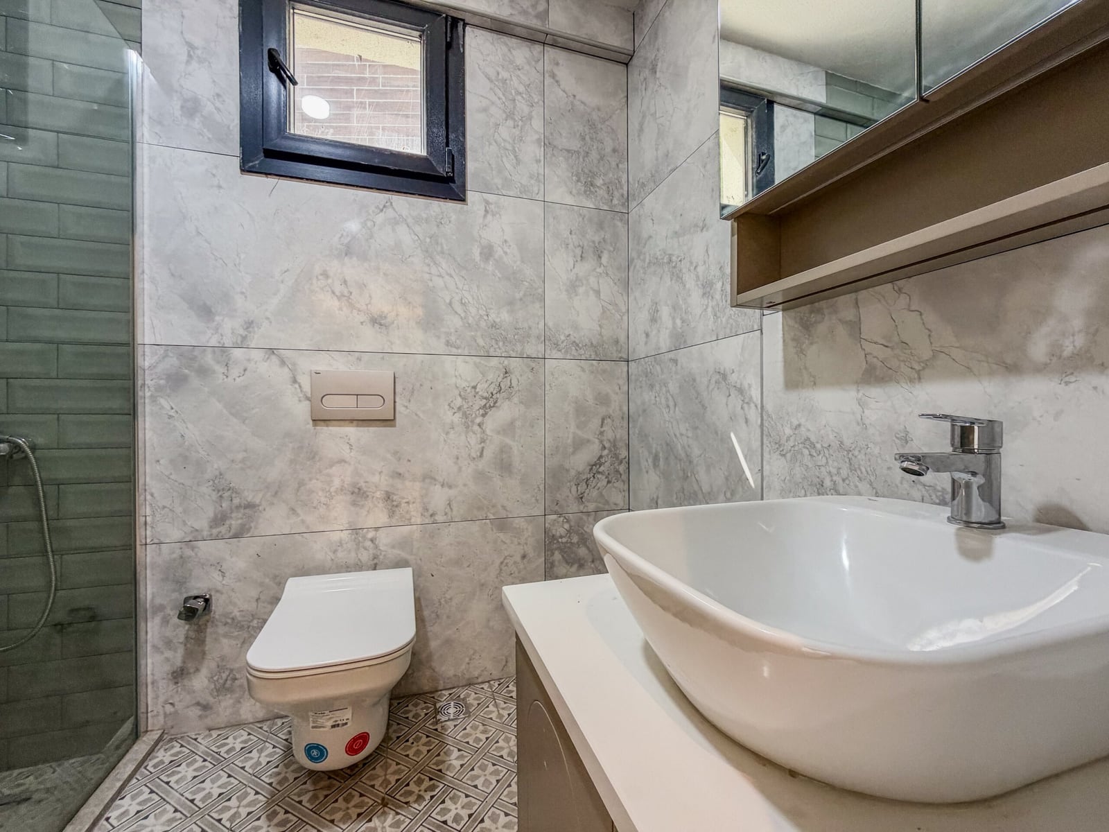 Modern bathroom with a shower cabin, sink, and tile finishes in an apartment in Budva, Montenegro