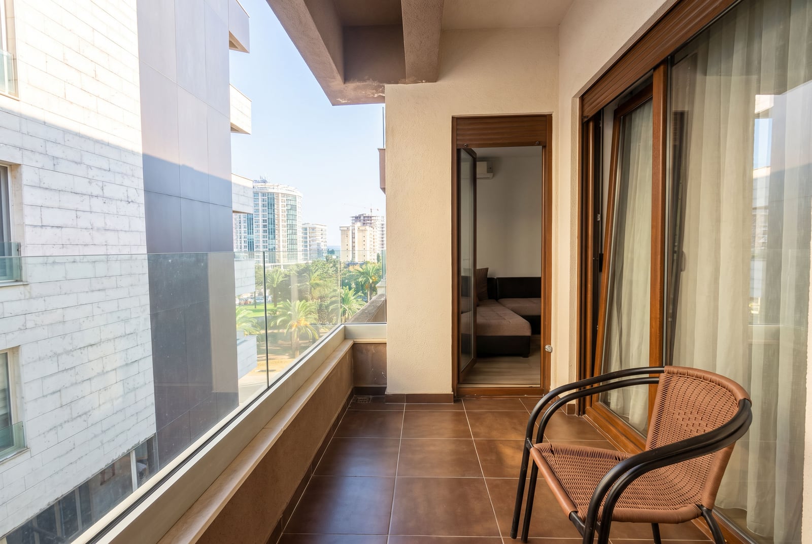 Geräumiger Balkon mit Korbstuhl und Panoramablick auf die Stadt in Budva, Montenegro
