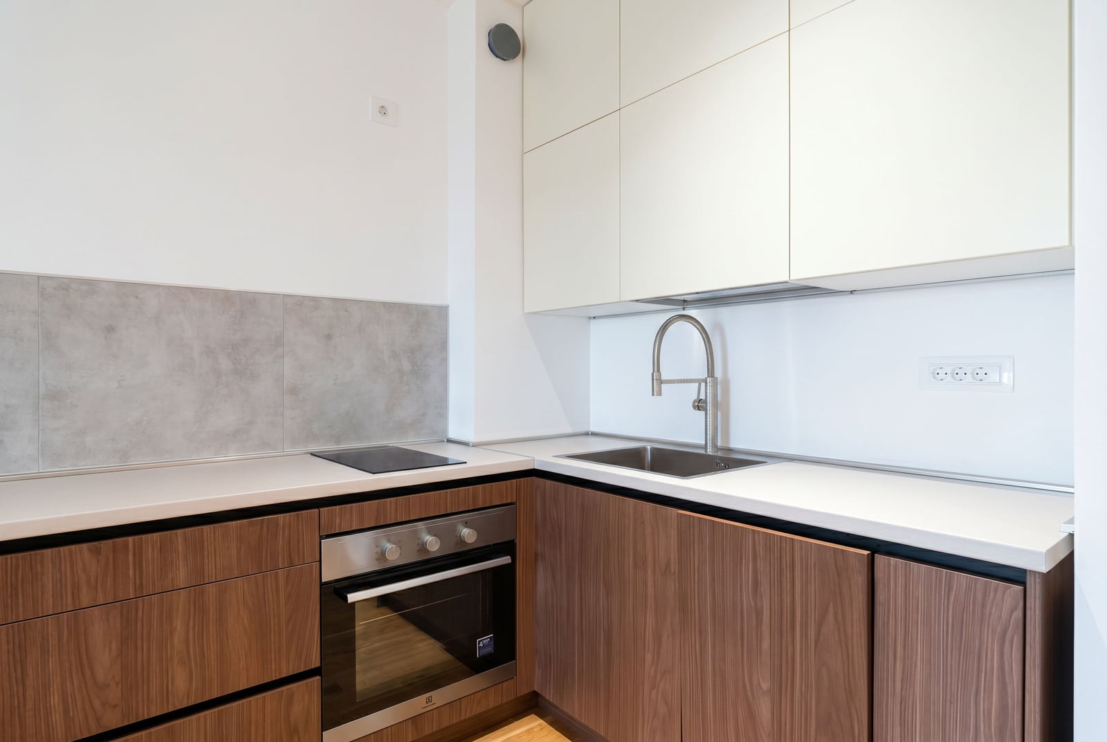 Modern kitchen in an apartment in Becici, Montenegro: built-in appliances, wooden cabinets, and a light-colored countertop.