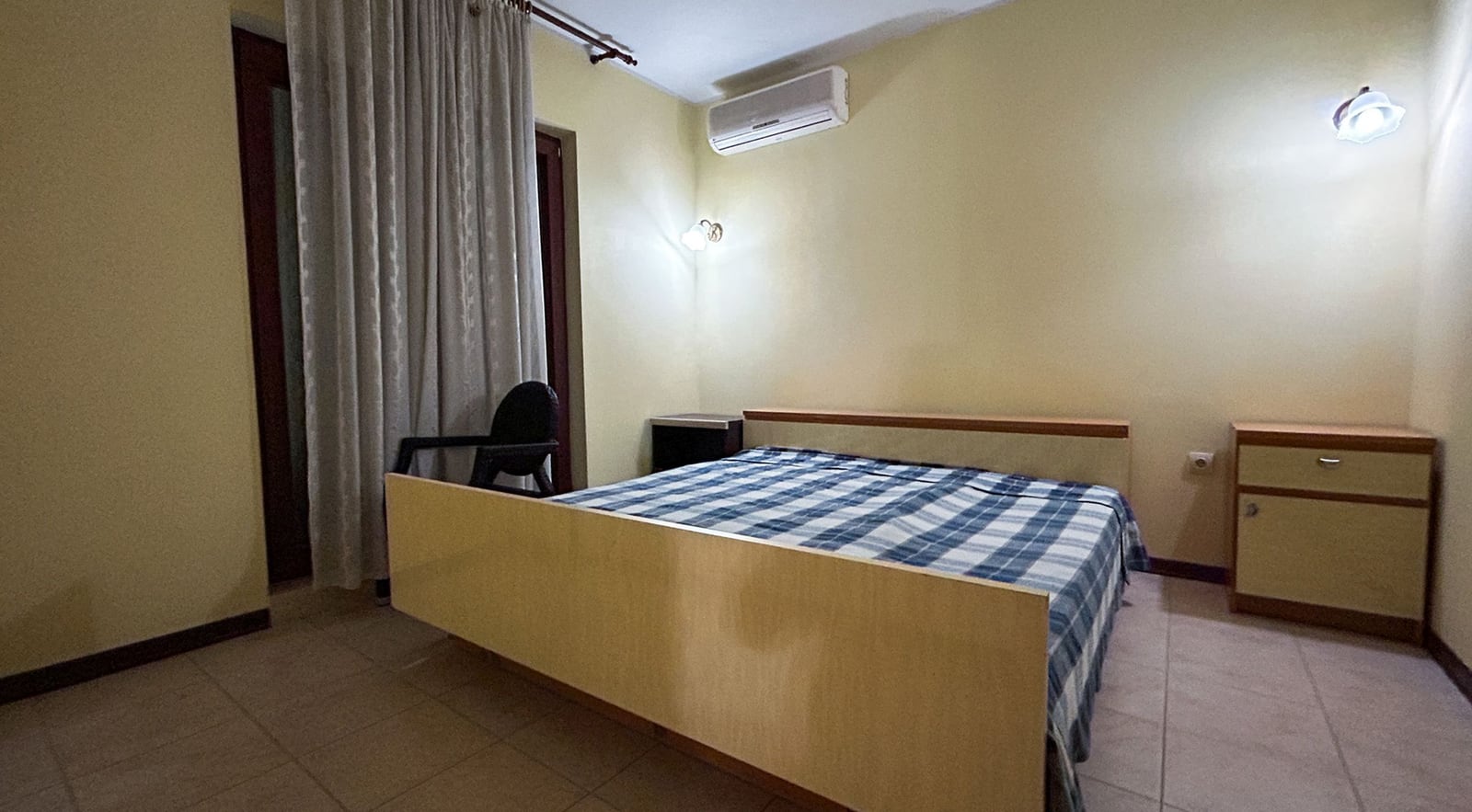 Schlafzimmer mit Doppelbett und Klimaanlage in einer Villa in Dobrota, Montenegro: helle Möbel und Zugang zur Terrasse.