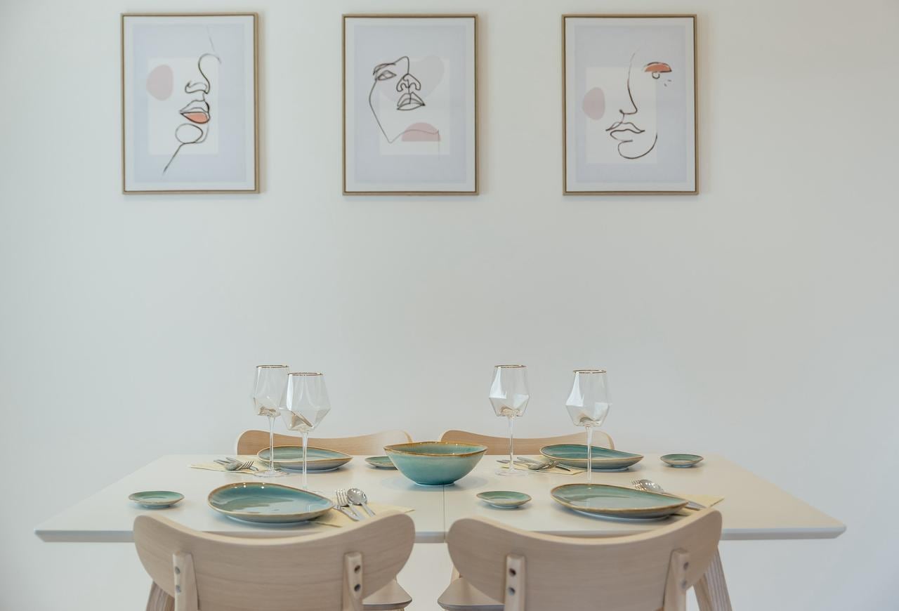 Gedeckter Esstisch im Interieur einer Wohnung in Igalo, Montenegro: helle Möbel und Wanddekoration.