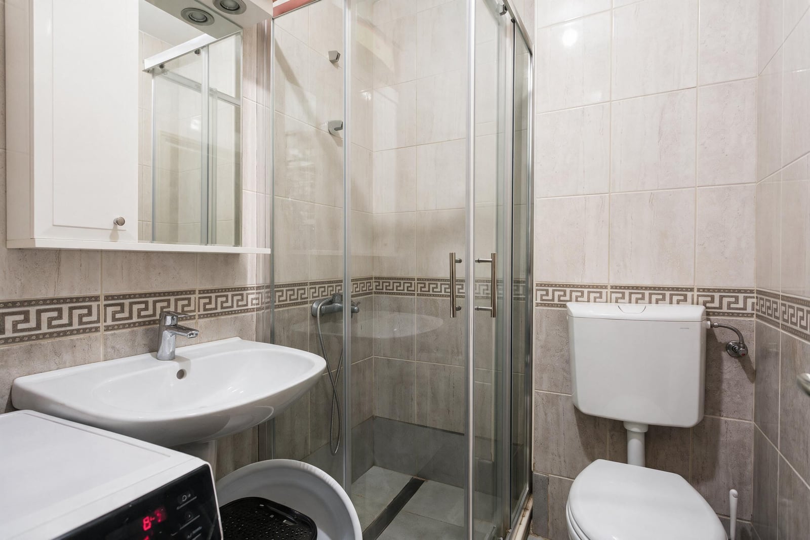 Modern bathroom with a shower enclosure and light tiles in an apartment in Igalo, Montenegro