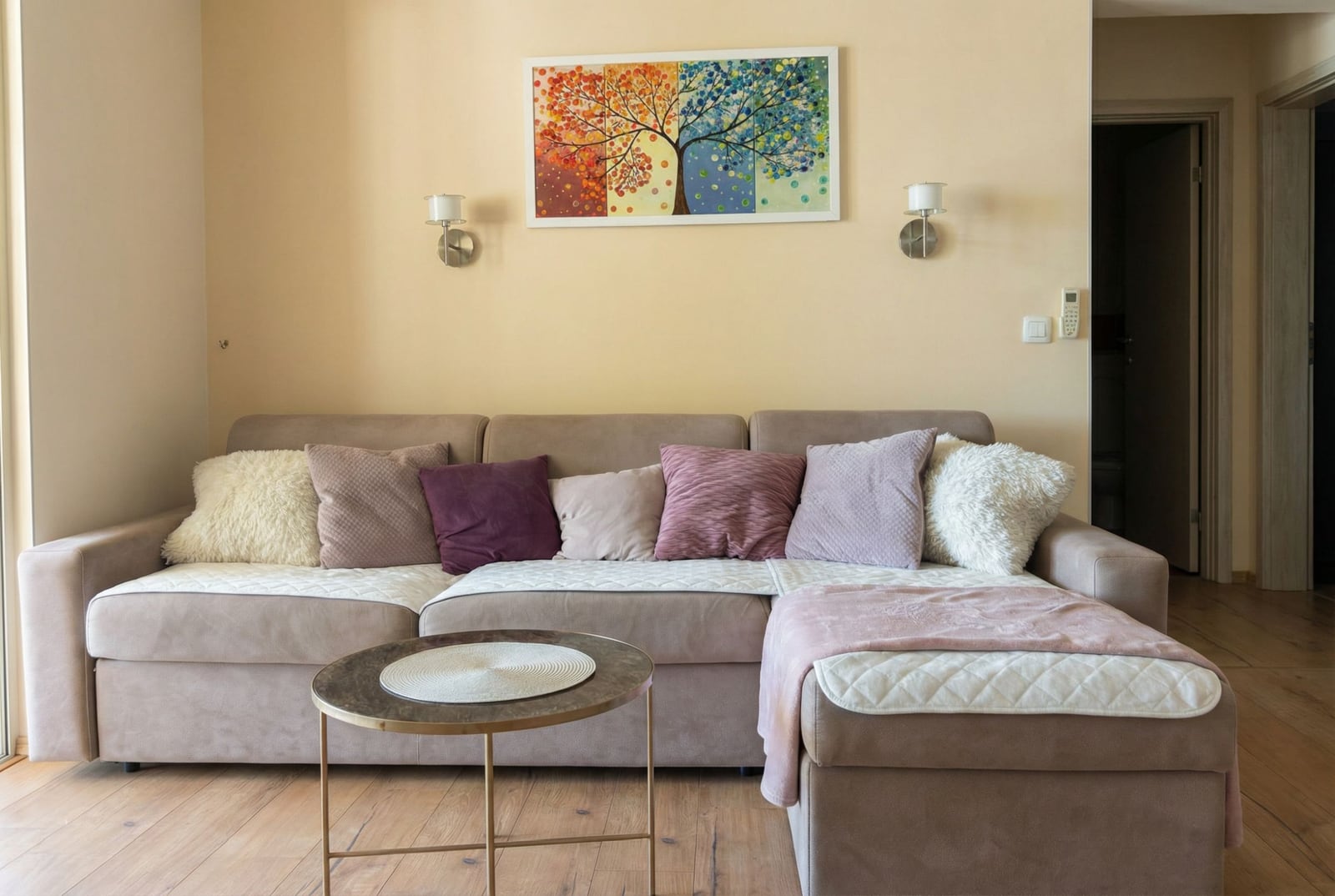Udobna dnevna soba u stanu u Pržnu, Crna Gora: bež ugaona sofa, stočić za kafu i slika na zidu.